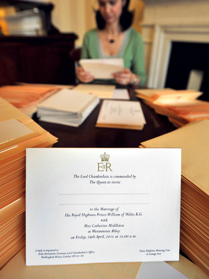 A member of the Lord Chamberlain's Office inserts invitations to the wedding of Prince William and Kate Middleton into envelopes