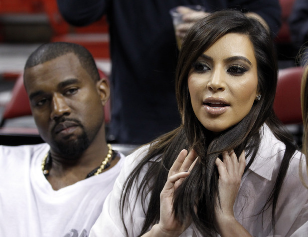 Kim Kardashian, right, and Kanye West, left, are shown before an NBA basketball game between the Miami Heat and the New York Knicks in this Dec, 6, 2012 file photo taken in Miami. The rapper Kanye West announced at a concert Sunday night Dec. 30, 2012 that his girlfriend is pregnant. He told the crowd of more than 5,000 at the Ovation Hall at the Revel Resort in song form: "Now you having my baby." ( AP Photo/Alan Diaz, File)